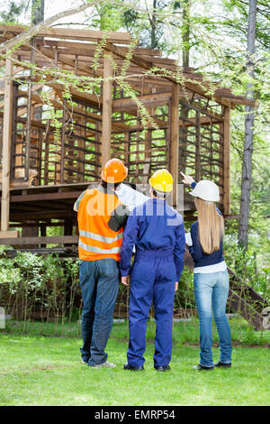 Architekten, diskutieren über unvollständige Blockhütte am Standort Stockfoto