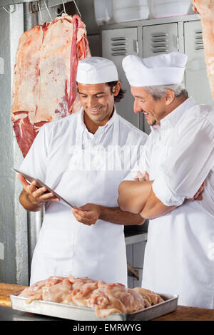 Metzger in Tablet Computer Metzgerei Suchen Stockfoto