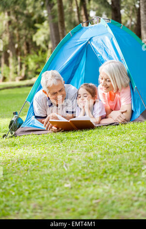 Großeltern Buch für Enkelin auf Campingplatz Stockfoto