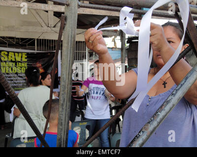 Quezon City, Philippinen. 23. April 2015. Ein Filipino bindet ein weißes Band während einer Diskussion im Sitio San Roque, über die Situation der philippinischen Todesreihe Gefangenen Mary Jane Veloso. Veloso, der verurteilt wurde, des Drogenhandels von einem indonesischen Gericht im Jahr 2010 ist geplant, zusammen mit neun anderen Ausländer nach der Bandung-Konferenz in Indonesien ausgeführt werden. © Richard James Mendoza/Pacific Press/Alamy Live-Nachrichten Stockfoto