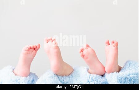 Nahaufnahme von zwei Babys Füße auf blaue Decke liegen. Platz für Text oben. Einfarbigen Hintergrund Stockfoto