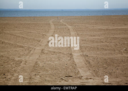 Reifenspuren im Sand am Strand von Coney Island am Atlantischen Ozean in Brooklyn, New York. Stockfoto