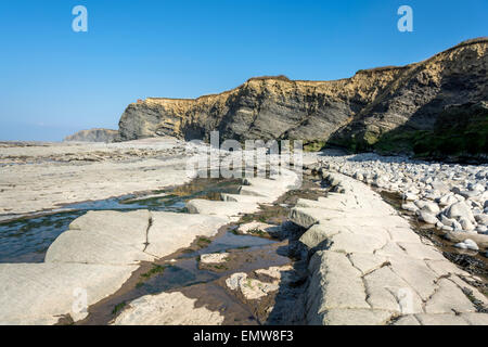 Schichten von Sedimentgestein bilden interessante Muster am Strand und in den Klippen am Kilve in Somerset, England, UK Stockfoto