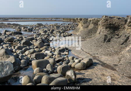 Schichten von Sedimentgestein bilden interessante Muster am Strand und in den Klippen am Kilve in Somerset, England, UK Stockfoto