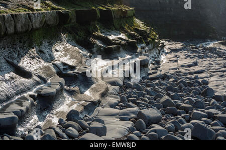 Schichten von Sedimentgestein bilden interessante Muster am Strand und in den Klippen am Kilve in Somerset, England, UK Stockfoto