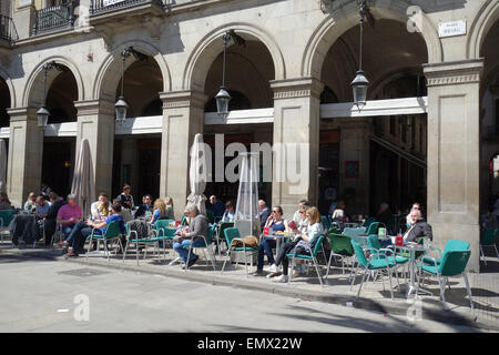 Leute sitzen im Restaurant Café im Freien in der Sonne im Plaza Real, Barcelona, Katalonien, Spanien Stockfoto