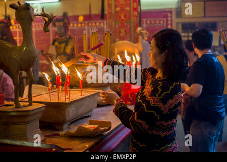 Chinesische Frau Beleuchtung Weihrauch steckt in einem Kloster in Hong-Kong (Man Mo Tempel) Stockfoto