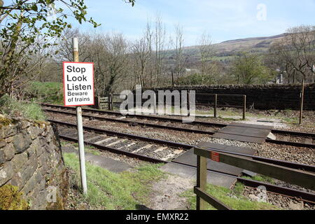 Ein Zug geht durch eine Fußgängerzone Bahnübergang in der Nähe von Uppermill Saddleworth Oldham England UK Stockfoto