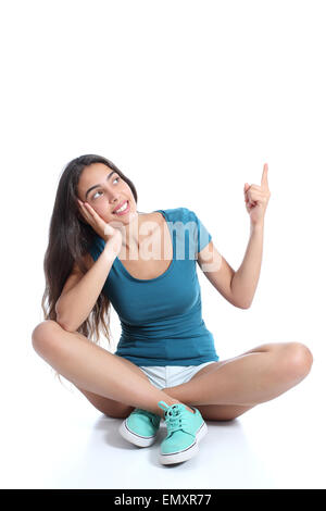 Teenager-Mädchen sitzen und deutete auf Seite isoliert auf weißem Hintergrund Stockfoto