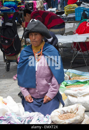 Frau Kaufmann mit Produkten auf dem Display zum Verkauf an Otavalo Markt, Ecuador Stockfoto