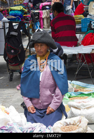 Frau Kaufmann mit Produkten auf dem Display zum Verkauf an Otavalo Markt, Ecuador Stockfoto