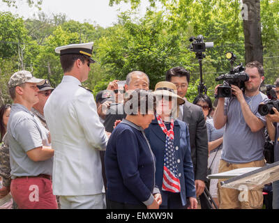 Croton-on-Hudson, NY - 26. MAI 2014: Gold Star bald Mutter Chay, dessen Sohn, Armee SSgt Kyu Hyuk Chay in Afghanistan getötet wurde, von Außenministerin Hillary Clinton während des Memorial Day Feier in die eine Brücke in der Stadt nach ihrem Sohn benannt wurde getröstet wird. SSgt Kyu Hyuk Chay, eine Armee Kryptologe, die erste Tour der Aufgabe im Irak überlebte, wurde in Südkorea geboren und emigrierte in die USA mit seinen Eltern in den 80er Jahren. Der SSgt Vater und überlebende Bruder stand gleich dahinter. Stockfoto