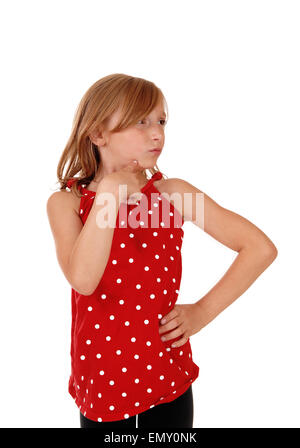 Eine hübsche und junge Mädchen in einem roten Kleid mit der Hand unter dem Kinn, auf der Suche entfernt, isoliert auf weißem Hintergrund. Stockfoto