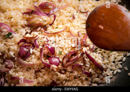 Nahaufnahme von Risotto mit roten Zwiebeln in einer Pfanne gekocht Stockfoto