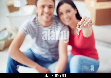 Junges Paar zeigt Schlüssel aus ihrem Haus Stockfoto