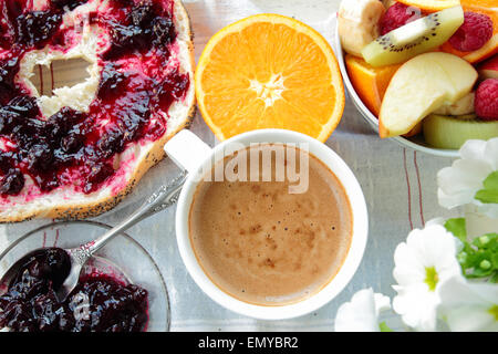 Frühstück mit Brot mit Johannisbeeren Marmelade, Kaffee und Obst Stockfoto