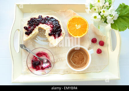 Tablett mit Frühstück. Roll mit Johannisbeeren Marmelade und eine Tasse Kaffee Stockfoto