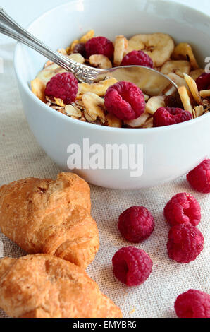 Schüssel mit Müsli mit frischen Beeren und croissants Stockfoto