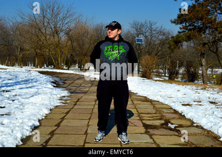 Mann mit Hoodie und Kappe zu Fuß durch den park Stockfoto