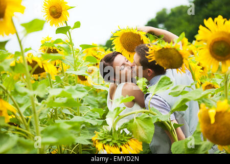 glückliches Paar in Liebe Spaß im Feld voller Sonnenblumen. Hochzeitspaar. fröhliche Frau und Mann. Liebe-Konzept. Freiheit Stockfoto