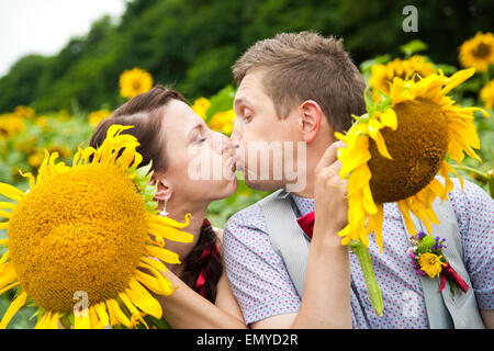 glückliches Paar in Liebe Spaß im Feld voller Sonnenblumen. Hochzeitspaar. fröhliche Frau und Mann. Liebe-Konzept. Freiheit Stockfoto