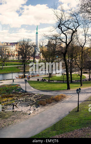 Blick auf das Freiheitsdenkmal in Riga Bastion Hügel im Park mit der Stadt und Kanal Boot im zeitigen Frühjahr Stockfoto