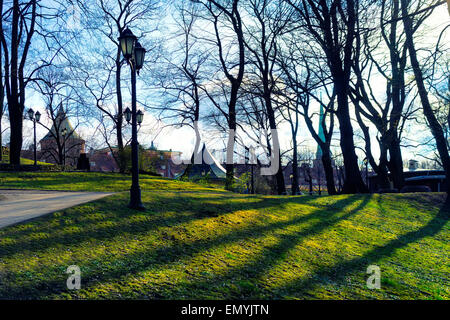 Park mit Bäumen ohne Blätter auf einem Hügel mit Blick auf die Bastion von Riga an einem sonnigen Tag im Frühjahr Stockfoto