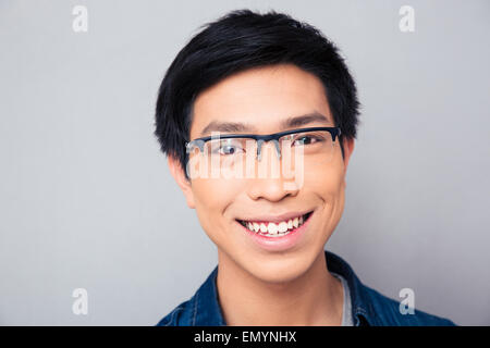 Closeup Portrait ein lächelnder asiatischen Mann auf grauem Hintergrund. Blick in die Kamera Stockfoto