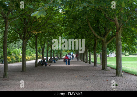 Paar, die Arm in Arm in einem von Bäumen gesäumten Park gehen. Parc du Thabor. Thabor Park. Rennes. Ile-et-Vilaine, Bretagne. Frankreich. Stockfoto