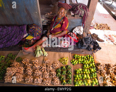 Wamena, Indonesien - 23. Januar 2015: Frau im Schatten sitzend und verschiedene Arten von Obst zu verkaufen. Stockfoto