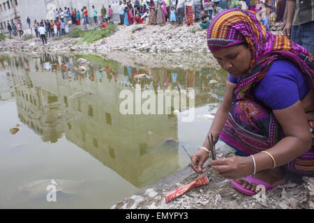 24. April 2015 - in der Nähe von Dhaka, Bangladesch - Verwandten des Opfers in den Zusammenbruch der Rana Plaza sitzt bezahlen ihren Tribut vor dem Zusammenbruch-Gelände in Savar, in der Nähe von Dhaka, Bangladesch getötet. (Kredit-Bild: © Suvra Kanti Das/ZUMA Wire/ZUMAPRESS.com) Stockfoto