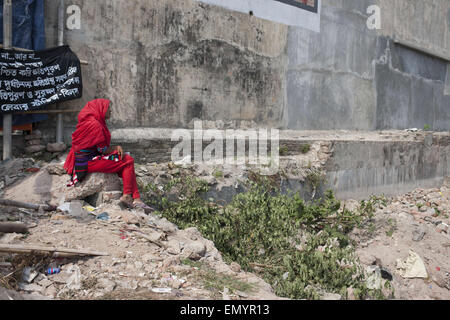 24. April 2015 - in der Nähe von Dhaka, Bangladesch - Verwandter eines Opfers, getötet in dem Zusammenbruch der Rana Plaza sitzt alleine vor dem Zusammenbruch-Gelände in Savar, in der Nähe von Dhaka, Bangladesch. (Kredit-Bild: © Suvra Kanti Das/ZUMA Wire/ZUMAPRESS.com) Stockfoto