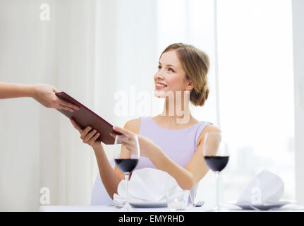 lächelnde Frau Kellner im Restaurant Menü verleihen Stockfoto