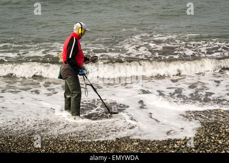 ADLER, Russland 30. März 2015 – Pensionär nutzt seine Freizeit auf Schatzsuche mit Hilfe eines Metalldetektors am Meer Stockfoto