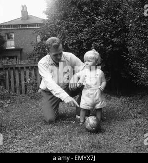 Manchester City Fußballer Don Revie abgebildet mit seinem Sohn Duncan im Garten hinter dem Haus der Familie zu Hause. 4. August 1955. Stockfoto