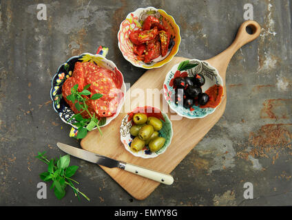 Antipasti, schwarze und grüne Oliven, mit Sonne getrocknet Tomate, Basilikum und Salami Stockfoto