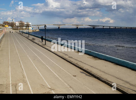 Eine Brücke erstreckt sich über einen großen Fluss mit weißen Wolken am Himmel Stockfoto