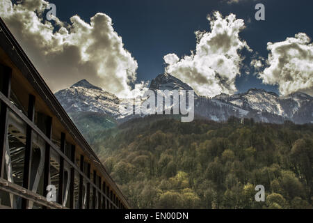 Weiße Wolken ragen Schnee spitzen Berggipfeln Stockfoto
