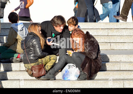 London, England, Vereinigtes Königreich. Familie auf den Stufen auf dem Trafalgar Square von der National Gallery Stockfoto