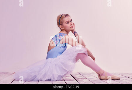 Sitzen auf dem Holzboden müde Ballett-Tänzerin Stockfoto