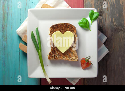 Herz Form Scheibe Käse auf geröstetem Vollkornbrot Stockfoto