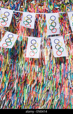 SALVADOR, Brasilien - 11. März 2015: Olympische Flagge Bunting hängt vor dem Hintergrund des guten Glücks brasilianische wünschen Bänder. Stockfoto