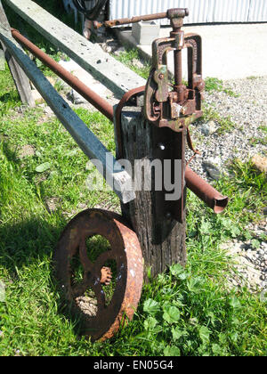 Die verrosteten Griff eine alte Wasserpumpe und Rad liegen in der Sonne auf einem Bauernhof in Nord-Kalifornien. Stockfoto