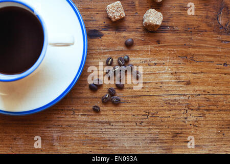schöne Kaffeekörner und Cup am Holztisch im Café, Hintergrund mit Platz für text Stockfoto