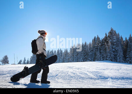 Silhouette der Frau mit Snowboard auf der Piste Stockfoto