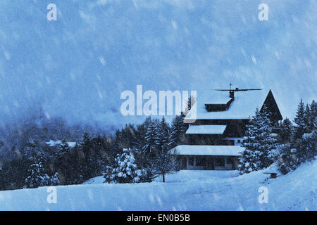 Schneefall und Holzhaus im Wald, Winter Hintergrund Stockfoto