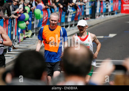 London, UK - 21. April 2013: Blinde Läufer und Führer Läufer beim London-Marathon arbeiten zusammen. Der London-Marathon geht weiter Stockfoto