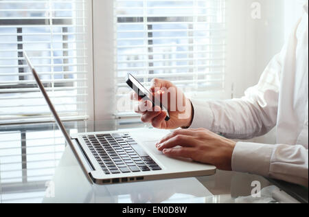 Geschäftsmann mit Smartphone im Büro Stockfoto