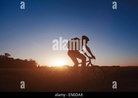 Silhouette der junge Mann auf dem Fahrrad bei Sonnenuntergang Stockfoto