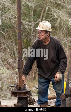 Ölarbeiter Waschbecken Rohre mit Hilfe einer Derrick für Rohöl in Evangeline, Louisiana zu bohren. Die Ölfelder wurden die ersten Brunnen in Louisiana. Stockfoto